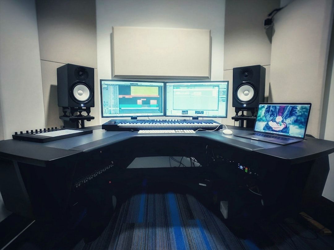 En professionell musikstudio med dubbla skärmar och studiomonitorer.